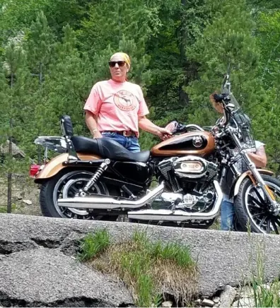Connie's staff photo from Stillwater Veterinary Clinic posing on her Harley outside 